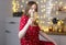 Woman at home decorated for christmas holding glass of wine and cheers close up