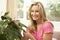 Woman At Home Looking After Houseplant