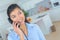 Woman at home talking on land line telephone