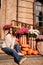 a woman in hoodies and sunglasses on the steps of a house on autumn street