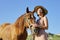 Woman with horse on blue sky background. Portrait with animals. Relationship background.