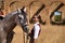 Woman horsewoman, young and beautiful, next to her horse, in the countryside next to a ruined building. Concept horse riding,