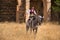 Woman horsewoman, young and beautiful, performing cowgirl dressage exercises with her horse, in the countryside next to a ruined