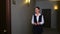 Woman hotel manager walks down the corridor and opens door of one of rooms.