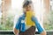 Woman housekeeper cleaning the mirror with yellow cloth.