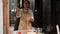 Woman housewife in beige chef apron, tossing up the ready yeast dough while preparing bread or pizza, in rustic kitchen