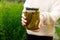 Woman housewife hand holding glass jar of pickled cucumbers. Domestic preparation pickling and canning of vegetables