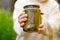 Woman housewife hand holding glass jar of pickled cucumbers. Domestic preparation pickling and canning of vegetables, winter