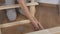 Woman housewife sitting in the room on the floor, collects wooden rack, bought in the store. Assembly of furniture.