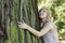 Woman hugging large tree trunk while looking up