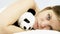 Woman hugging panda plush falling asleep