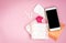 Woman hygiene protection. Sanitary pads with pain pill, pink rose and mobile phone on pink background. Menstrual cycle tracking