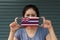 A woman and hygienic mask with Hawaii flag pattern in her hand and raises it to cover her face. A mask is a very good protection