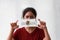 A woman and hygienic mask with Illinois flag pattern in her hand and raises it to cover her face on white background