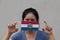 A woman and hygienic mask with Missouri flag pattern in her hand and raises it to cover her face. A mask is a very good protection