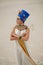 Woman in image of egyptian queen Nefertiti stands in desert with whip