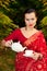 Woman in Indian sari with teapot and cup of tea