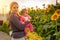 Woman with infant enjoying sunrise in the garden of sunflowers. Holding baby on the hands