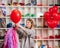 a woman inflates of helium from a red balloon.