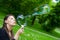 Woman inflating colorful soap bubbles