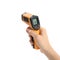 Woman with infrared thermometer on white background, closeup. Checking temperature during Covid-19 pandemic
