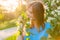 Woman inhales the fragrance of spring flowers of blooming jasmine tree