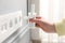 Woman inserting wireless Wi-Fi repeater into power socket indoors, closeup