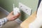 Woman inserting wireless Wi-Fi repeater into power socket indoors, closeup