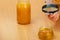 Woman inspecting honey with magnifying glass.