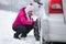 Woman installing tire chain