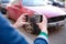 Woman insurance broker making photo of car after accident on smartphone