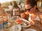 Woman intent on eating fish in restaurant at sunset, Zakynthos, Greece