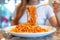 woman intently eating spaghetti, plate piling high