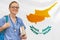 Woman intern doctor with stethoscope and books against Cyprus flag background. Medical education in Cyprus