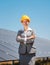 Woman investor in clean energy standing in front of solar panels
