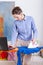 Woman ironing clothes and checking email on her laptop