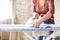 Woman ironing garment at home