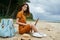 Woman on the island with a laptop on her legs backpack travel internet technology