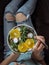 Woman in jeans at bed, holding vegan salad bowl