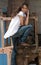 Woman in jeans and white shirt standing next to some woods