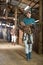 Woman jockey with saddle and bridle in her hands in stable