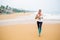 Woman is jogging along the seashore on an overcast day