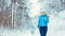 Woman jogging towards camera in cold and snowy forest