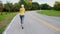 A woman jogs along the path in a beautiful well-groomed park. Back view, gimbal shot