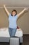 Woman joyfully raised her hands in a hotel room, vacation concept