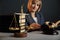 Woman judje isolated in office with books and justice scales and wooden gavel.