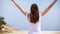 Woman jump with joy along sand path. Carefree female raising arms up and dancing in slow motion