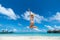 Woman Jumping In The Air On Tropical Beach