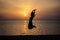 Woman jumping beautiful silhouette against the sea and dawn