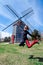 Woman jumping in front of the Eastham Windmill. The historic old fashioned mill sits in a Cape Cod Park in Massachusetts. Fisheye